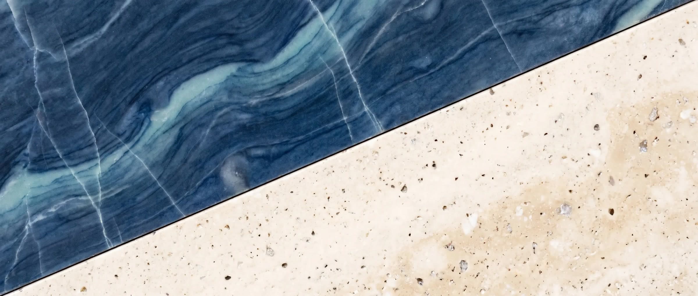 Blue water-veined stone meeting pale travertine along one clean diagonal